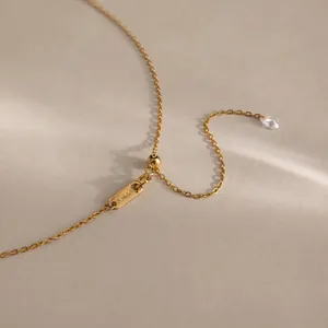 Dettaglio collana regolabile in acciaio dorato con cursore e zircone a goccia
