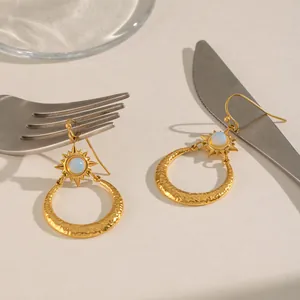 Detailansicht der Vintage-Sonne-Mond-Ohrringe mit gehämmerter Goldoptik und weißem Opal.