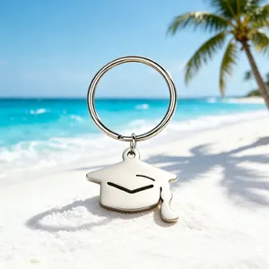 Primo piano di un portachiavi a forma di tocco da laureato su una spiaggia tropicale