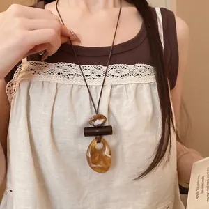 Collana con ciondolo in resina bohémien vintage con cordino in pelle marrone e ambra