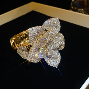 Exaggerated luxury flower-shaped bracelet with sparkling crystal pavé and gold finish.