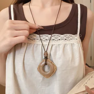Primo piano di una collana bohémien vintage con pendente in resina e cordino in pelle