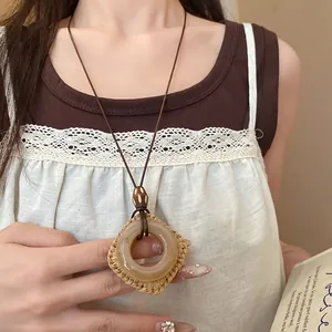 Dettaglio di una collana bohémien in resina con cornice quadrata intrecciata