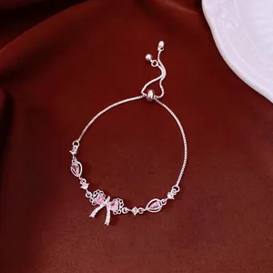 Elegant silver-toned bowknot bracelet with pink zircons and adjustable pull closure