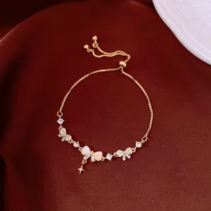 Close-up of elegant gold-toned bracelet featuring zircon bows and an adjustable draw-string