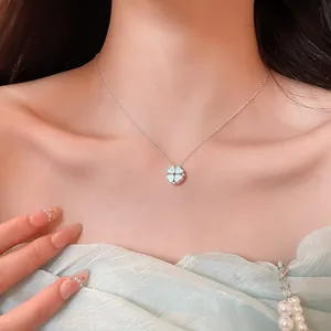 Elegant silver clover pendant necklace with zircon inlay on model's collarbone detail