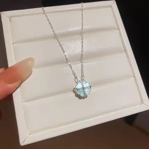 Detailed close-up of a silver four-leaf clover necklace with shimmering blue inlay