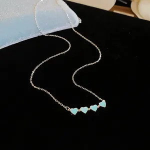 Elegant silver chain necklace featuring four delicate light blue heart-shaped pendants.