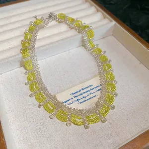 Close-up of handmade yellow and clear crystal beaded necklace with scallop patterns