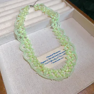Detailed view of light green beaded flower necklace in a premium jewelry display box
