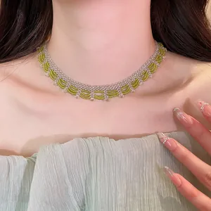 Close-up view of an elegant green beaded scalloped necklace worn on a model's neck