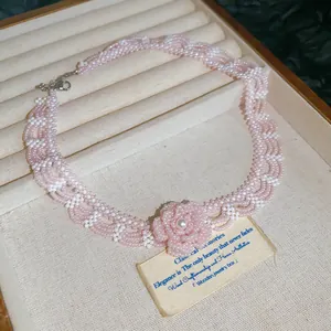 Detailed view of pink crystal beaded choker featuring an elegant pearl flower pendant