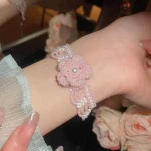 Delicate handmade pink beaded flower bracelet with pearl center on wrist
