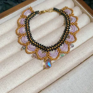 Detail of handmade beaded necklace with lavender accents and iridescent crystal pendant.