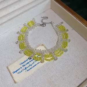 Close-up of yellow and transparent crystal seed bead necklace in a beige jewelry box