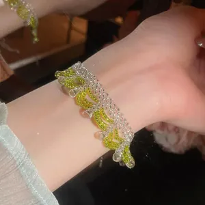 Exquisite detailed macro view of a green and clear crystal beaded bracelet on a woman's wrist