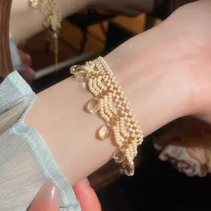 Detailed close-up of a handmade beaded bracelet featuring elegant water-drop pendants
