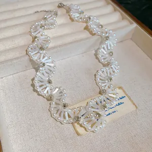 Close-up of elegant handmade white pearl and crystal beaded wavy choker necklace