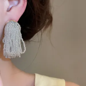 Close-up of elegant clear beaded tassel earring on ear with delicate craftsmanship