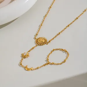 Dettaglio della catena da mano in acciaio dorato con pendenti a forma di sole e luna