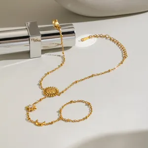 Dettaglio del bracciale da mano in acciaio inossidabile dorato con sole luna e stelle