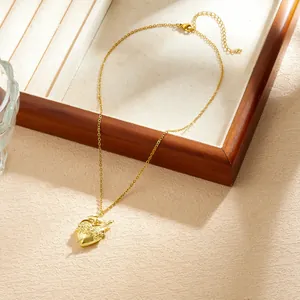 Detail view of Gothic gold plated heart pendant necklace with sword and rose design