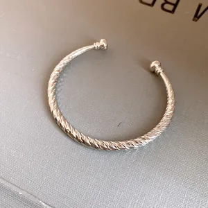 Gedetailleerd overzicht van een zilveren getextureerde armband met baluiteinden en design