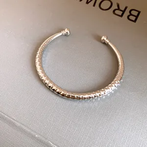 Gedetailleerde weergave van zilveren open armband met elegante gehamerde diamantgeslepen textuur