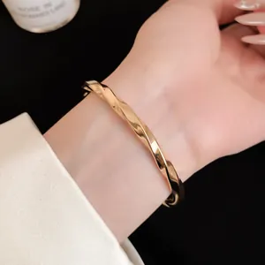 Gedetailleerde close-up van de glanzende afwerking van een gouden open armband