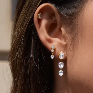 Boucles d'oreilles élégantes en acier titane avec zircon poire portées sur l'oreille