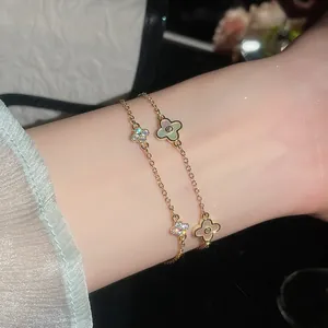 Makro-Detailansicht der 14K vergoldeten Kleeblatt-Armbänder mit Zirkonia und Perlmutt.