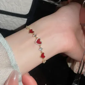 Detailansicht eines 14k vergoldeten Herzarmbands mit Zirkonia-Steinen am Handgelenk