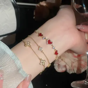Nahaufnahme von 14 Karat vergoldeten Herz- und Kleeblattarmbändern mit Perlmutt