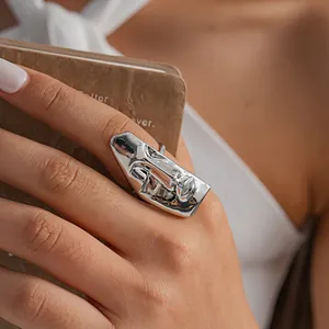 Vista dettagliata di un anello artistico in argento con maschera facciale astratta