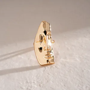 Dettaglio di un anello a maschera astratta dorata con una lucida finitura metallica