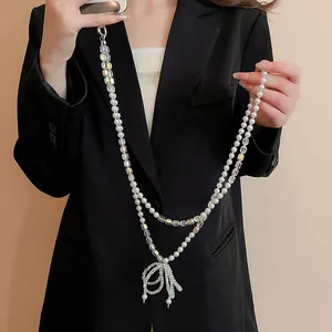 Détail de la lanière de téléphone en perles et cristal avec breloque nœud élégant