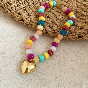 Dettaglio ravvicinato della collana di perle acriliche con ciondolo a cuore d'oro