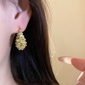 Elegant French-style gold textured hollow basket earrings worn by model lifestyle shot