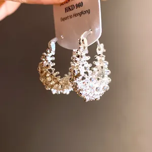 Close-up detail of exquisite French hollow silver basket hoop earrings with textured finish