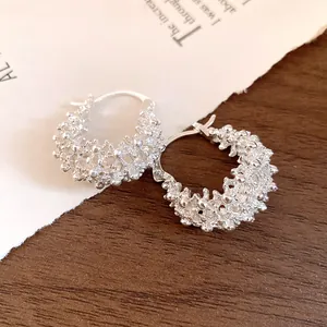 Detailed macro view of silver hollow basket hoop earrings with a unique textured finish