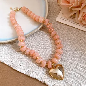 Detailed view of a pink resin beaded heart necklace with dopamine style aesthetic