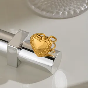 Detailed view of a gold stainless steel heart locket ring with ornate vintage engraving