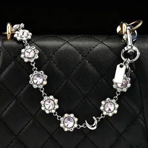 Elegant silver-tone bag extender chain featuring crystal flower charms on black leather
