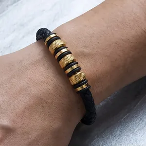 Macro view of men's black braided leather bracelet featuring knurled gold steel beads