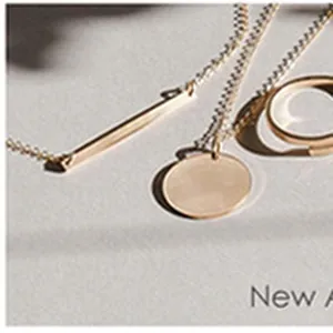 Gros plan sur un collier minimaliste en acier inoxydable doré avec pendentifs