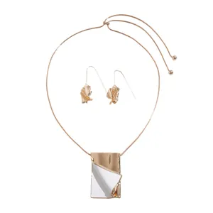 Artistic gold-tone book pendant necklace and earrings set with white enamel detail