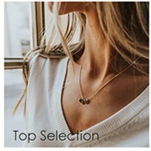 Gros plan d'un collier minimaliste avec pendentif cœur en acier inoxydable doré pour femme