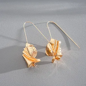 Detailed view of gold-finished earrings featuring a unique crumpled metal leaf design