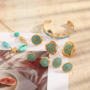 Detailed shot of 18K gold plated marine jewelry collection with blue enamel motifs.