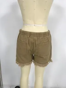 Back view of khaki high-waisted elastic denim shorts with frayed tassel hem